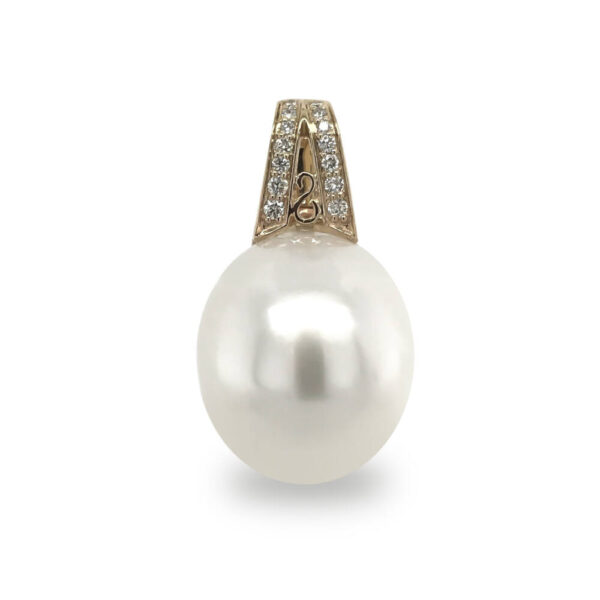 A large 16mm by 18mm Australian South Sea Cultured Pearl, drop-circle in shape, grade 2 with a AAA luster set on a 14 carat yellow gold enhancer set with 14 diamonds totaling 0.12 carats.
